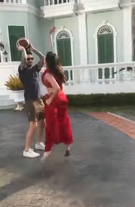 Sunny is seen playing basketball in a red saree with her husband