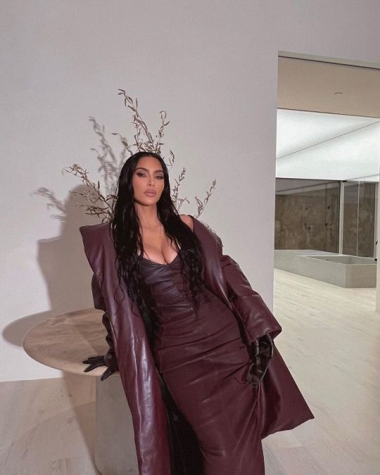 Wearing a coat with a brown dress, Kim added a touch of beauty