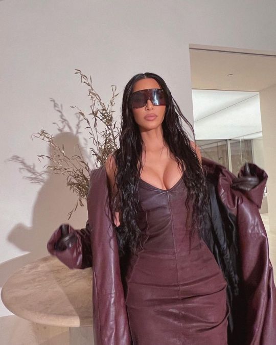 Wearing a coat with a brown dress, Kim added a touch of beauty