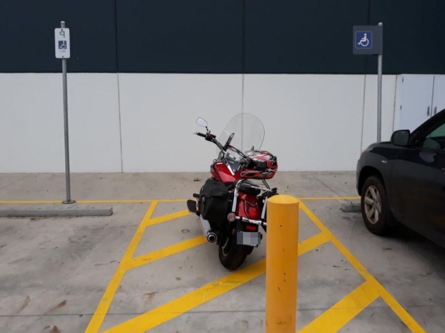 दो विकलांग पार्किंग स्थलों के बीच बाइक पार्क करने पर छिड़ी बहस, वायरल हुई तस्वीर