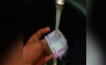 Video: Man washing Rs. 2000 note in a running water!