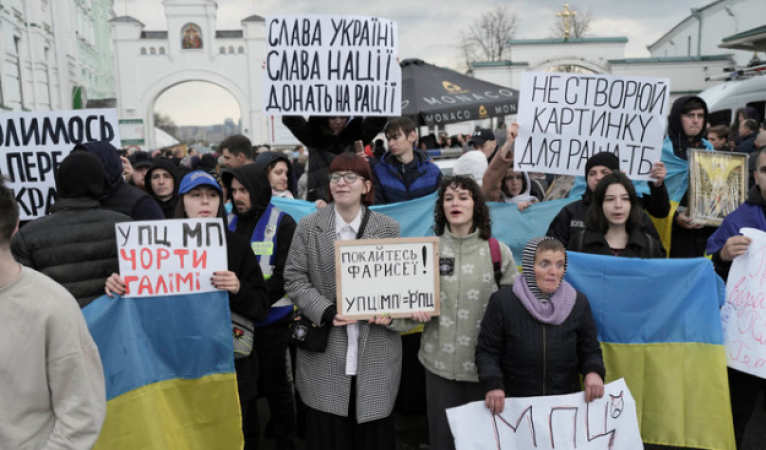 In Kyiv protesters clash as a clergyman's home is searched