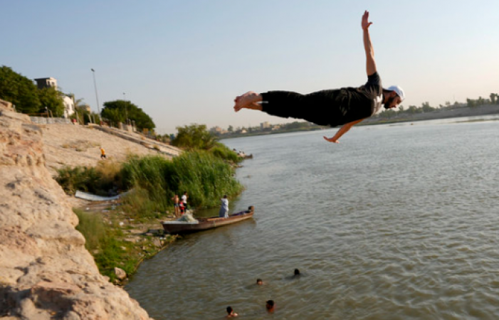 Iraqis swim in the receding Tigris to escape the summer heat