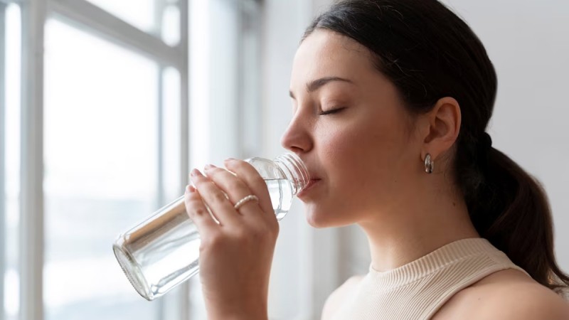 How much water should women drink a day in summer and why?