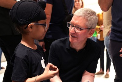 Apple CEO Tim Cook sits on his knees for baby in Delhi