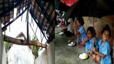 A school in Odisha where children hold umbrellas with one hand, eat food from the other