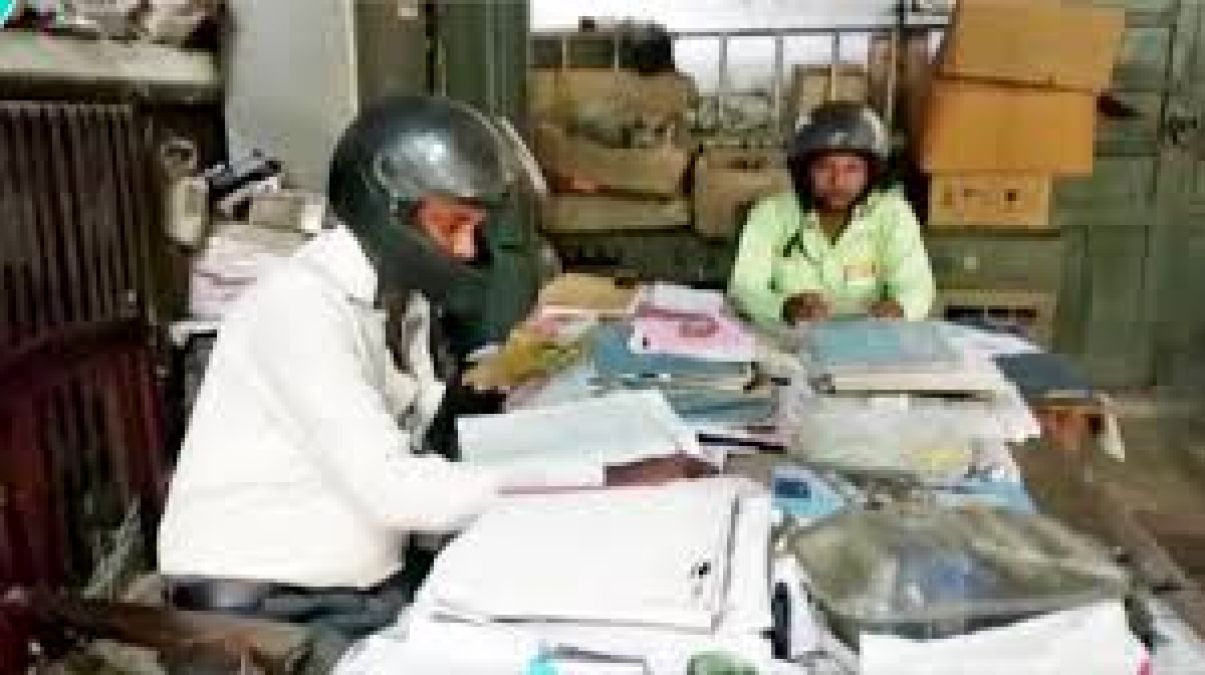 Employees working in helmets in a dilapidated building of Banda's power office