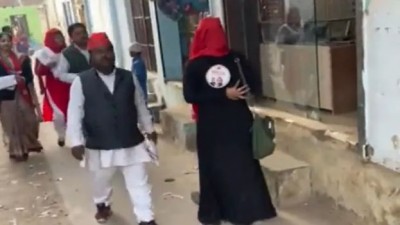 बुर्कानशीं महिला की पीठ पर सपा कार्यकर्ता ने चिपकाया पोस्टर, वायरल हुआ Video