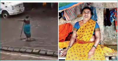Woman stood at an open manhole on Matunga road to warn drivers passing through the road