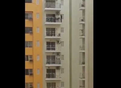 Dare Devil video: Man exercises by hanging from a railing in 12th-floor balcony