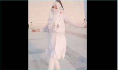 A girl in full hijaab dances at the front of Muhammad Ali Jinnah's tomb for her TikTok video