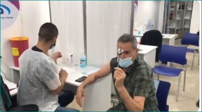 Israeli illusionist mystically bends spoon while getting vaccinated