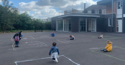 Kids sit in boxes to maintain social distancing in school playground