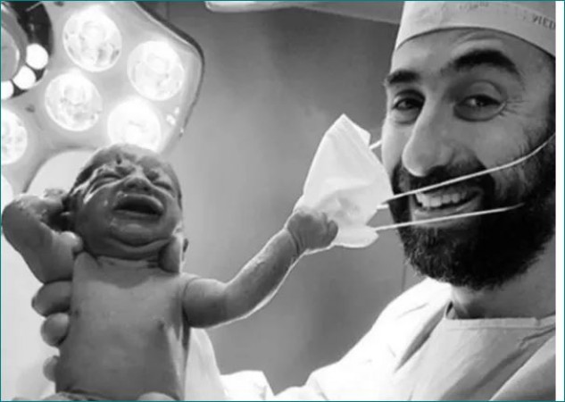 Picture of newborn baby trying to take off doctor's mask goes viral
