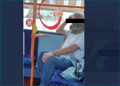 Man travels in bus by wearing a snake as a face mask
