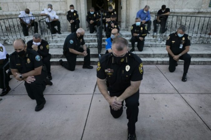 America: Police sit on their knees in front of protesters